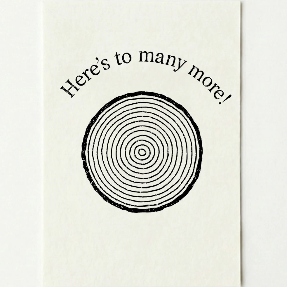 'Here's to many more!' card on a plain white background.